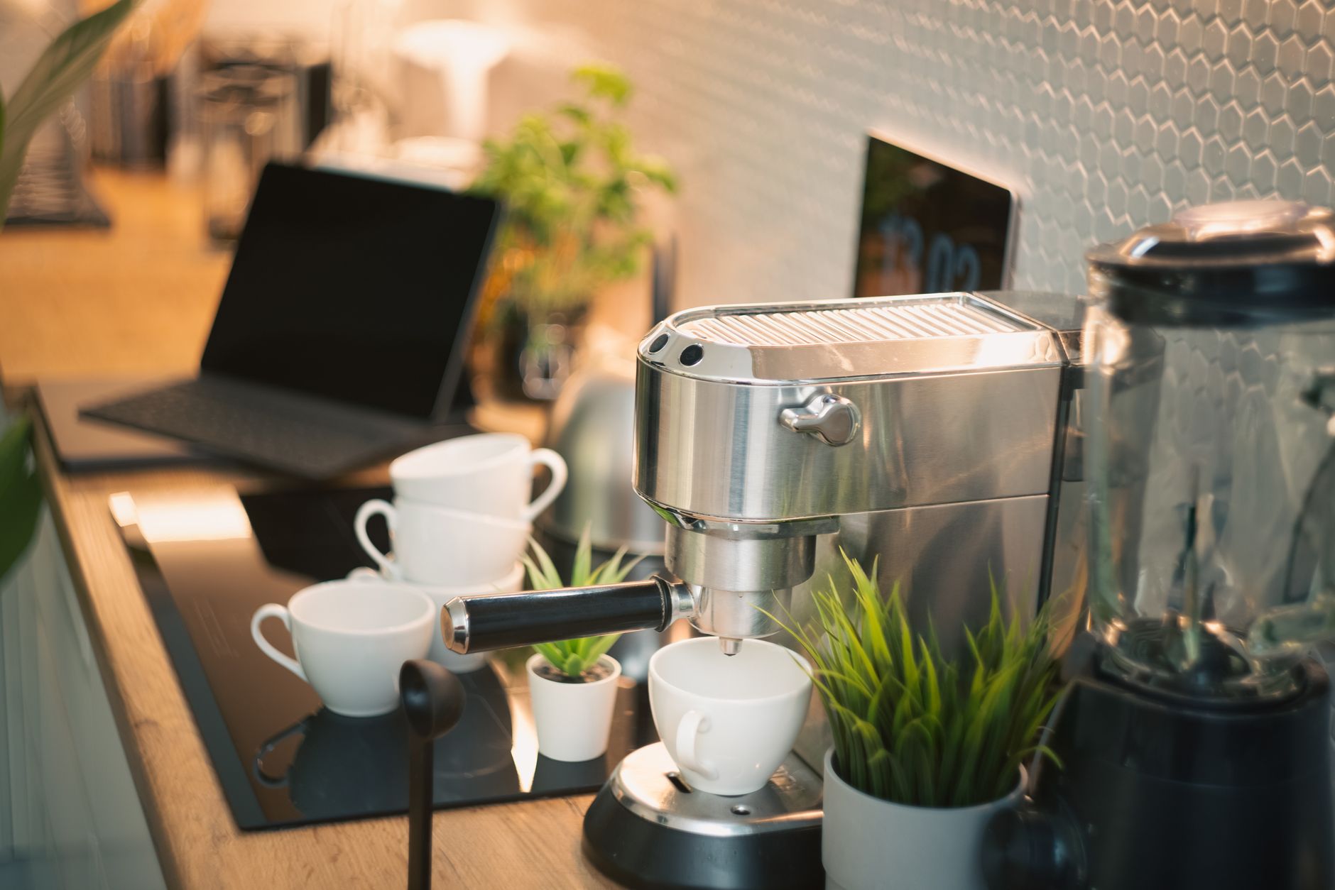 Narrow strip of counter holding a coffee maker and two stacked mugs