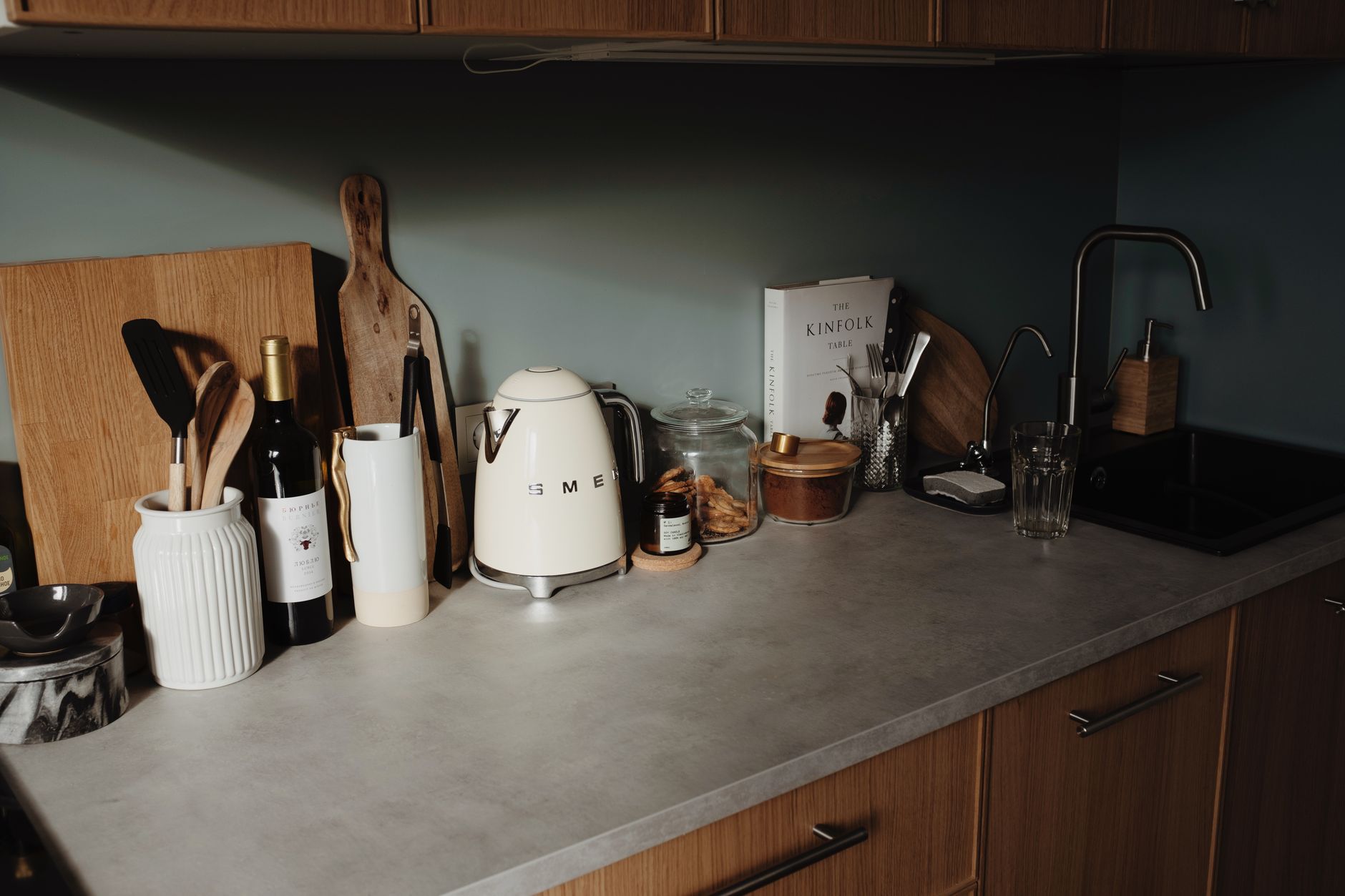 Cream stoneware crock holding spoons beside a coffee grinder