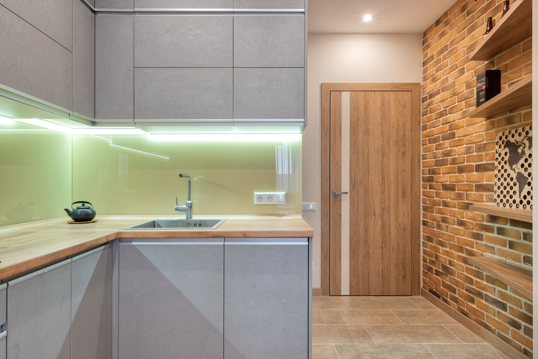 Warm under-cabinet lighting washing down over a short section of counter and backsplash